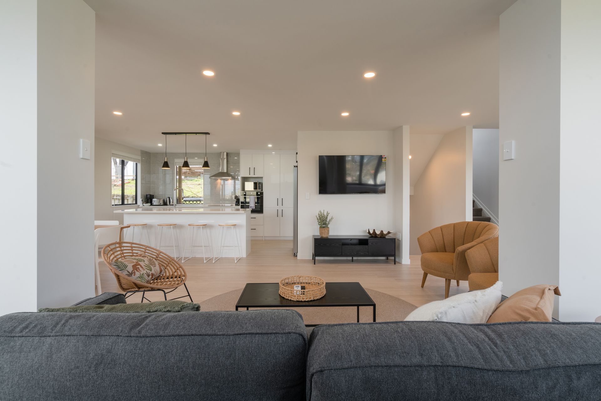 Spacious open-plan living area with a kitchen, living room, and a brown armchair.