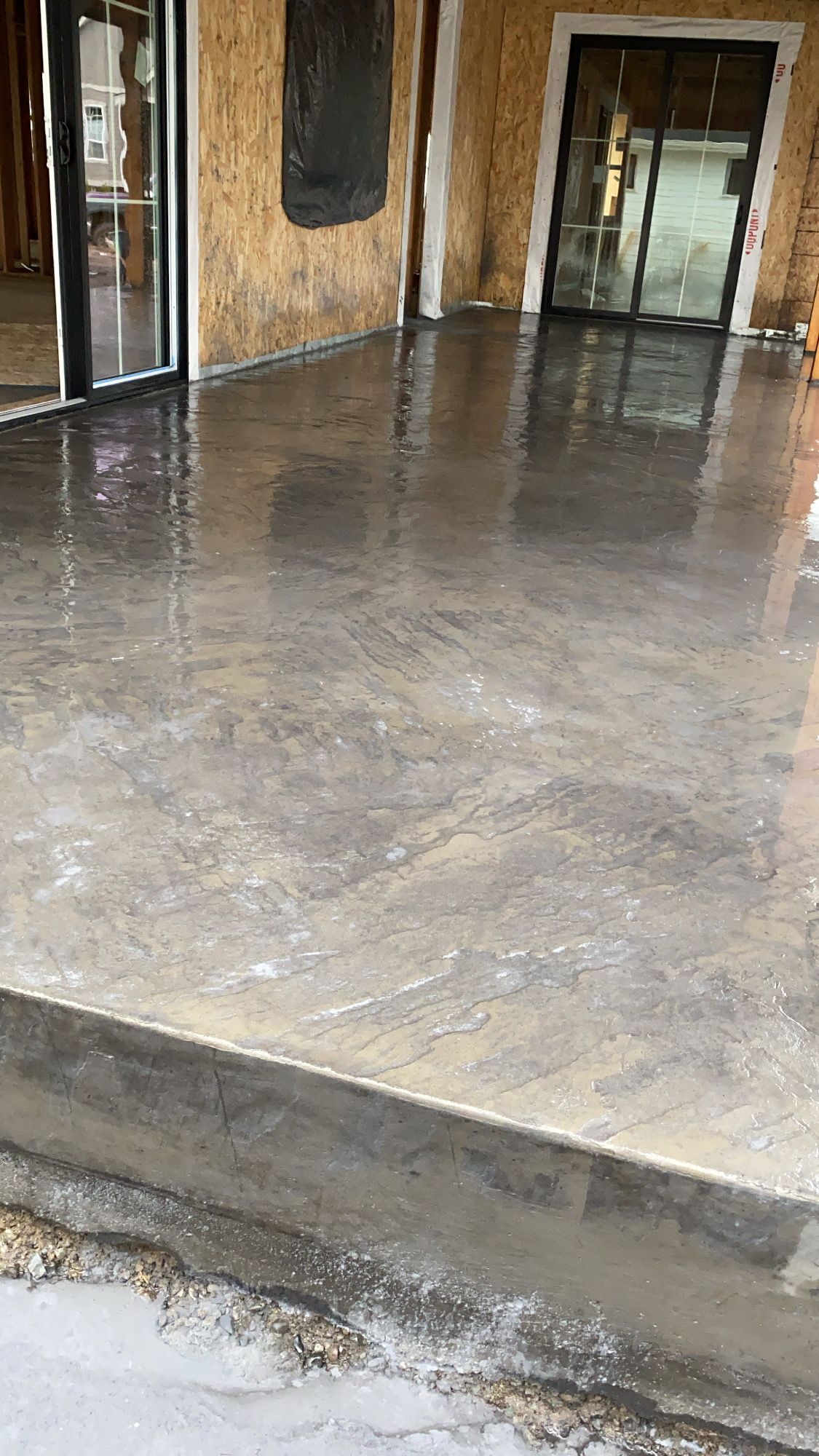 A concrete floor is being installed in front of a building.