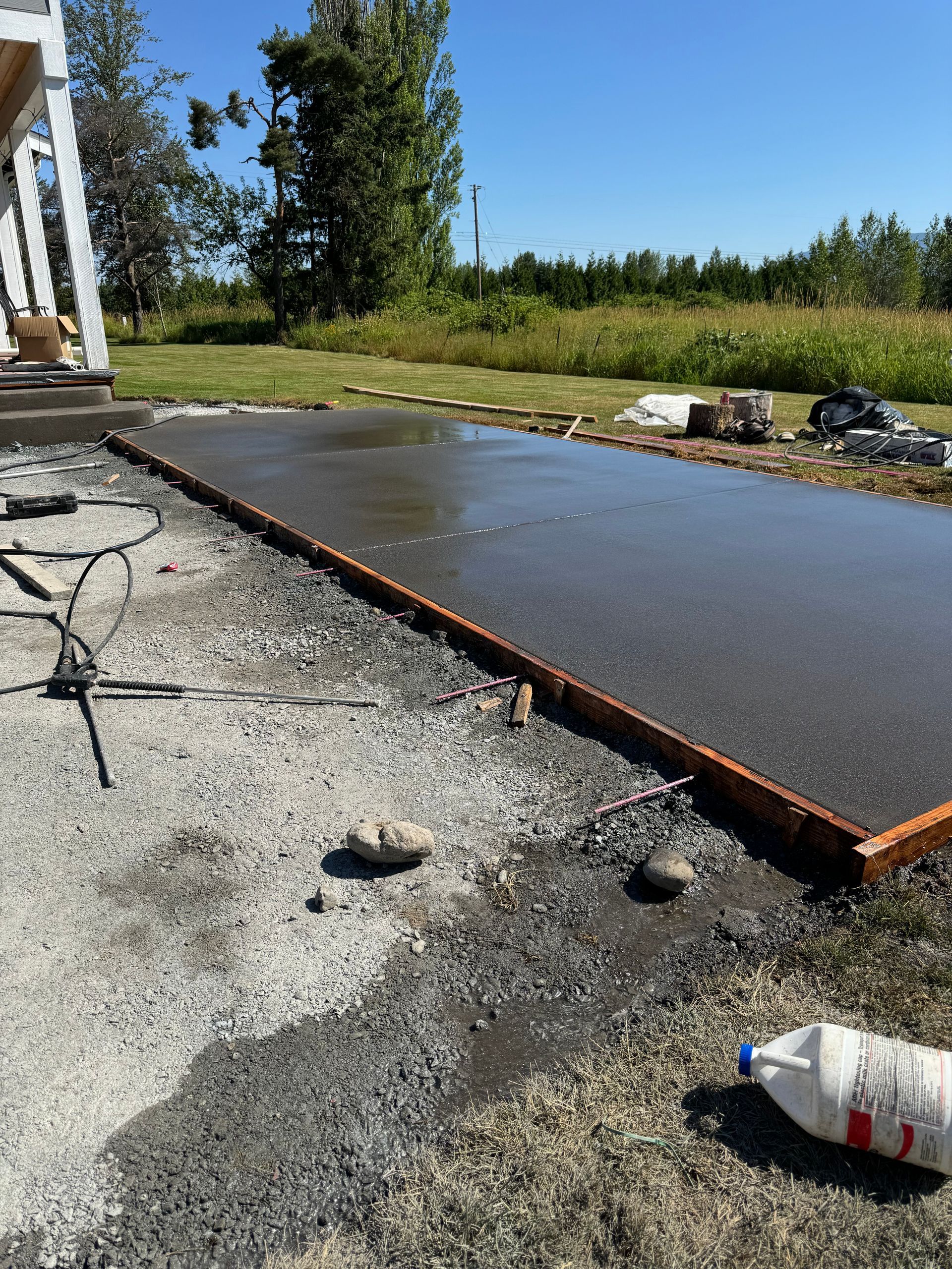 A bottle of milk is laying on the ground next to a concrete slab.