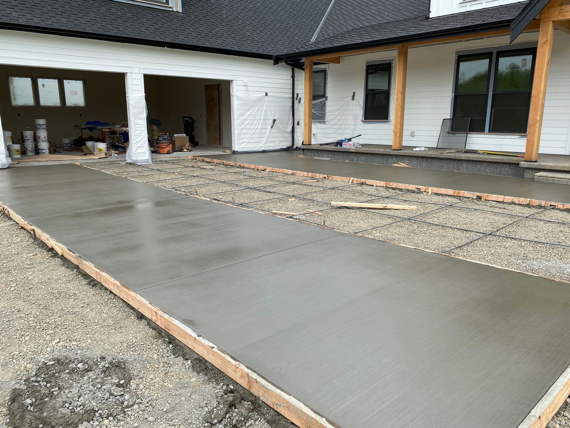 A concrete driveway is being built in front of a house.