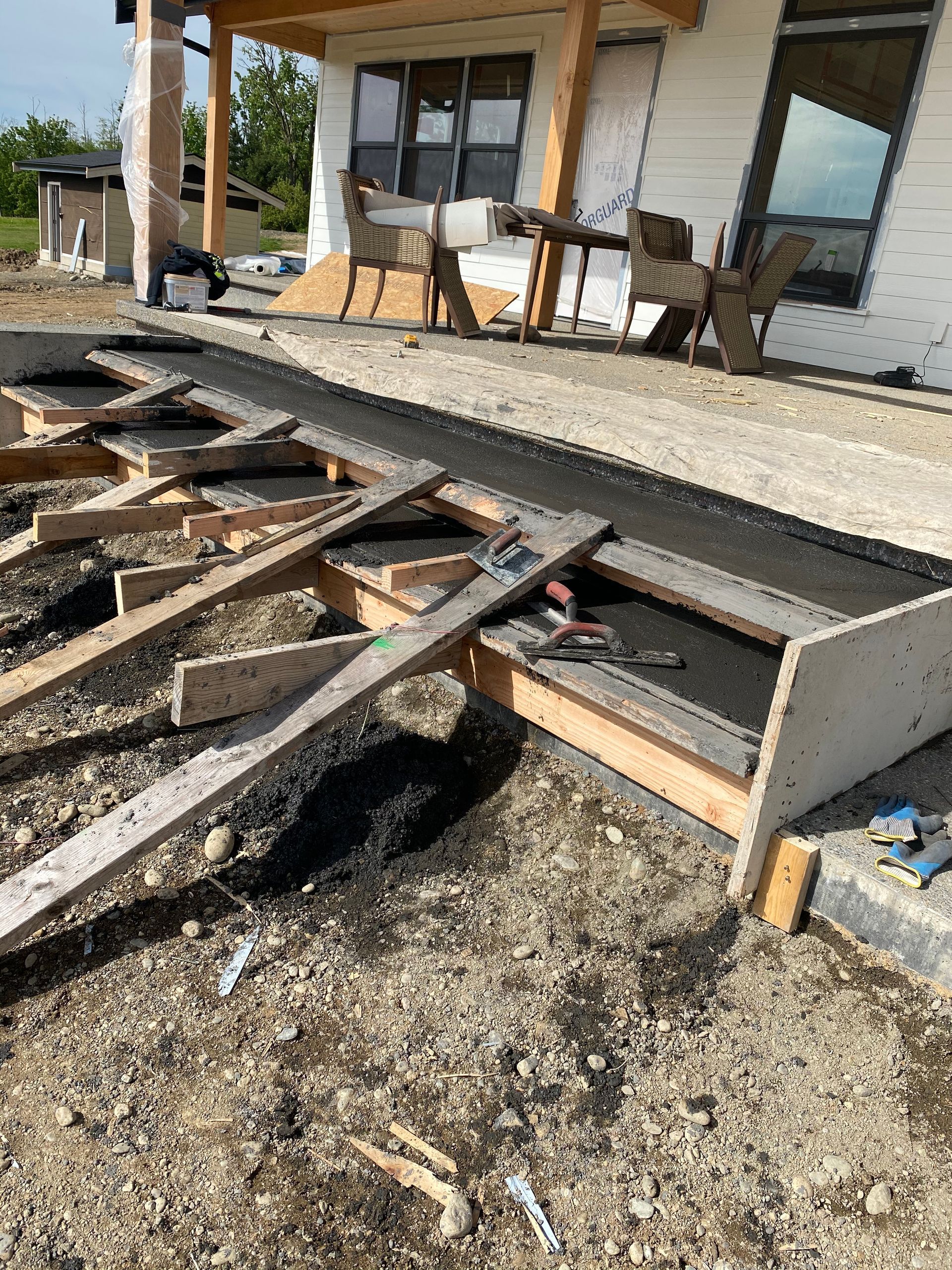 A wooden deck is being built in front of a house.