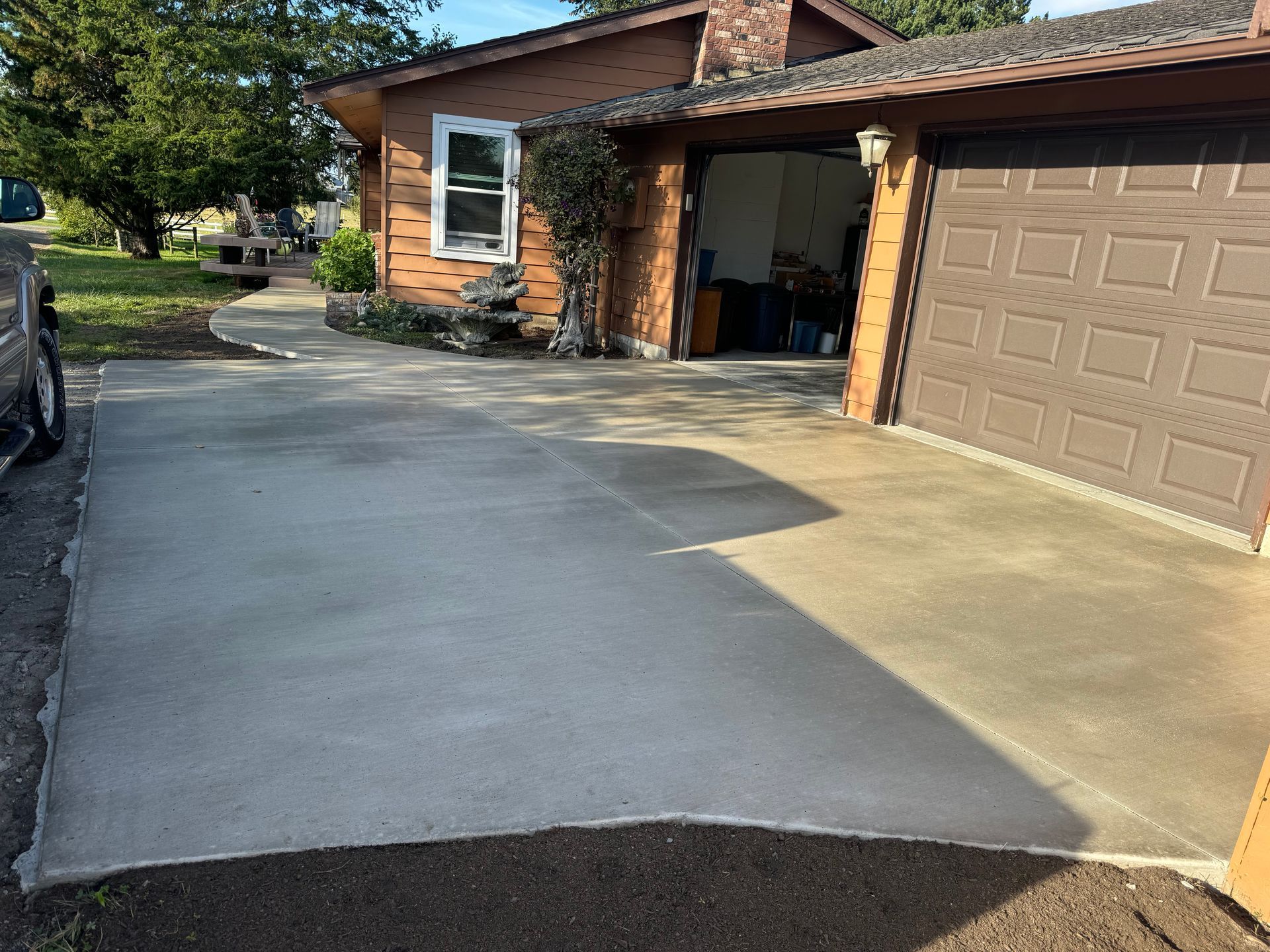 A concrete driveway in front of a house with a garage door.