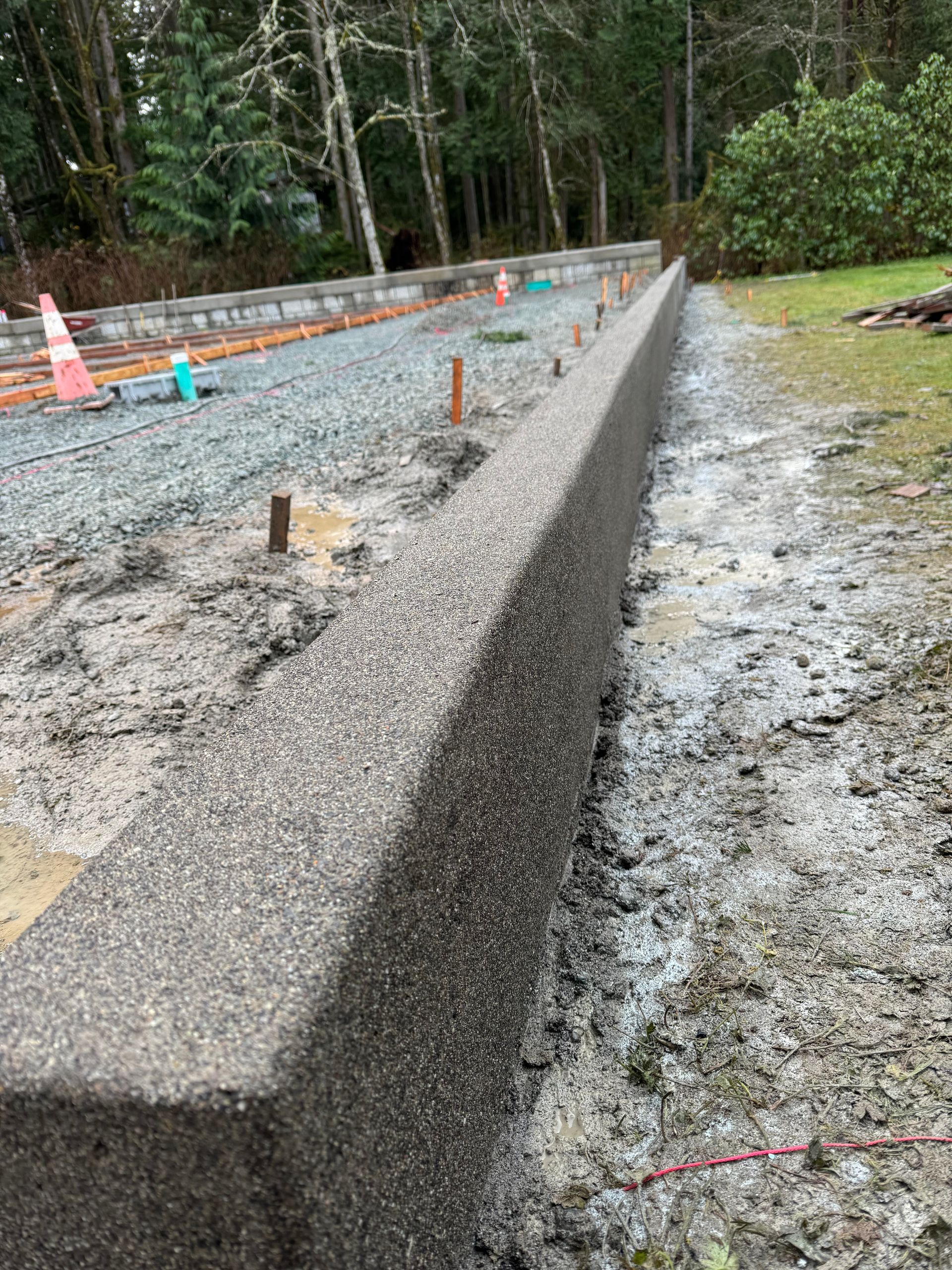 A concrete wall is being built on the side of a road.