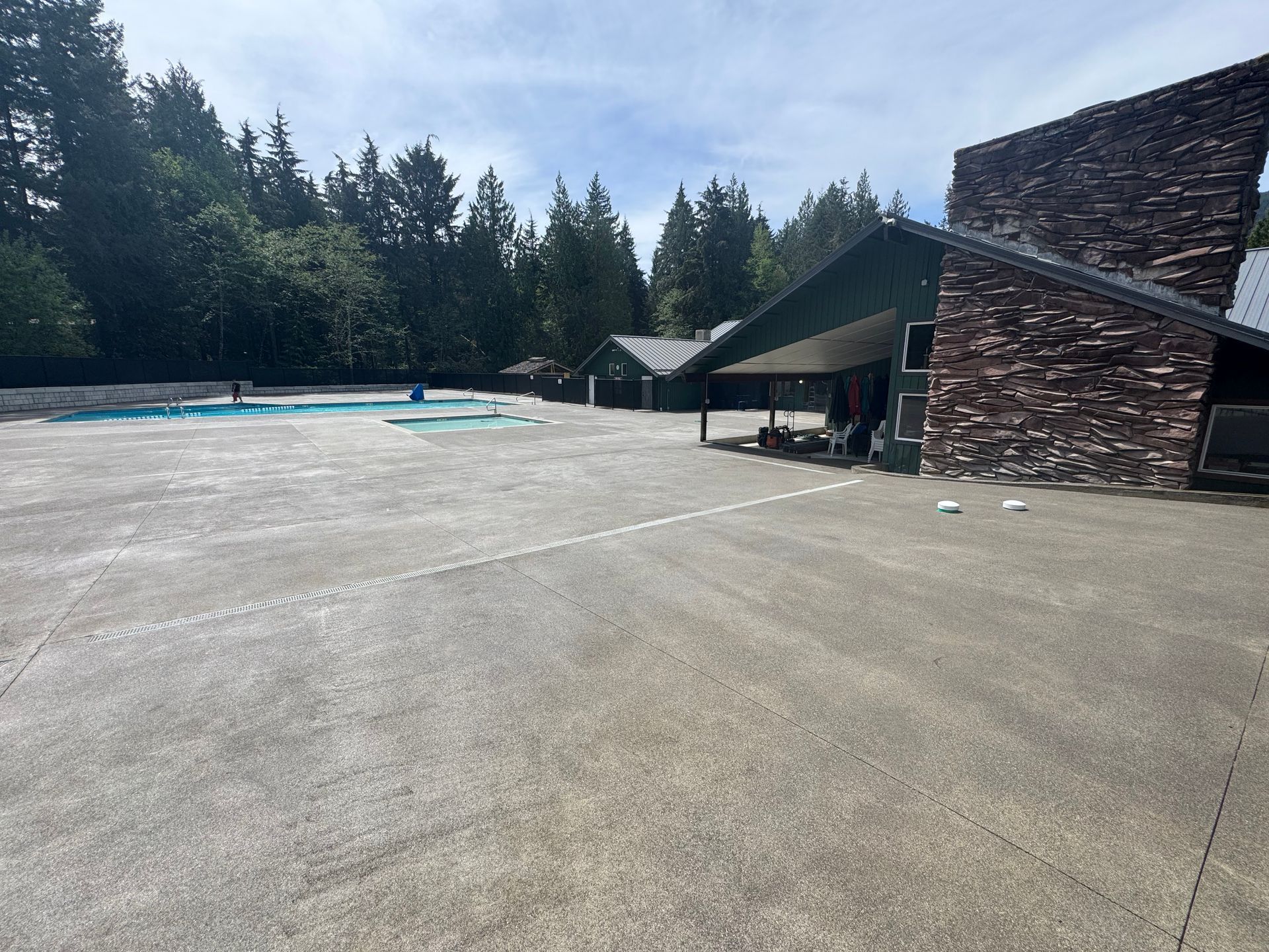 A large parking lot with a swimming pool in the background