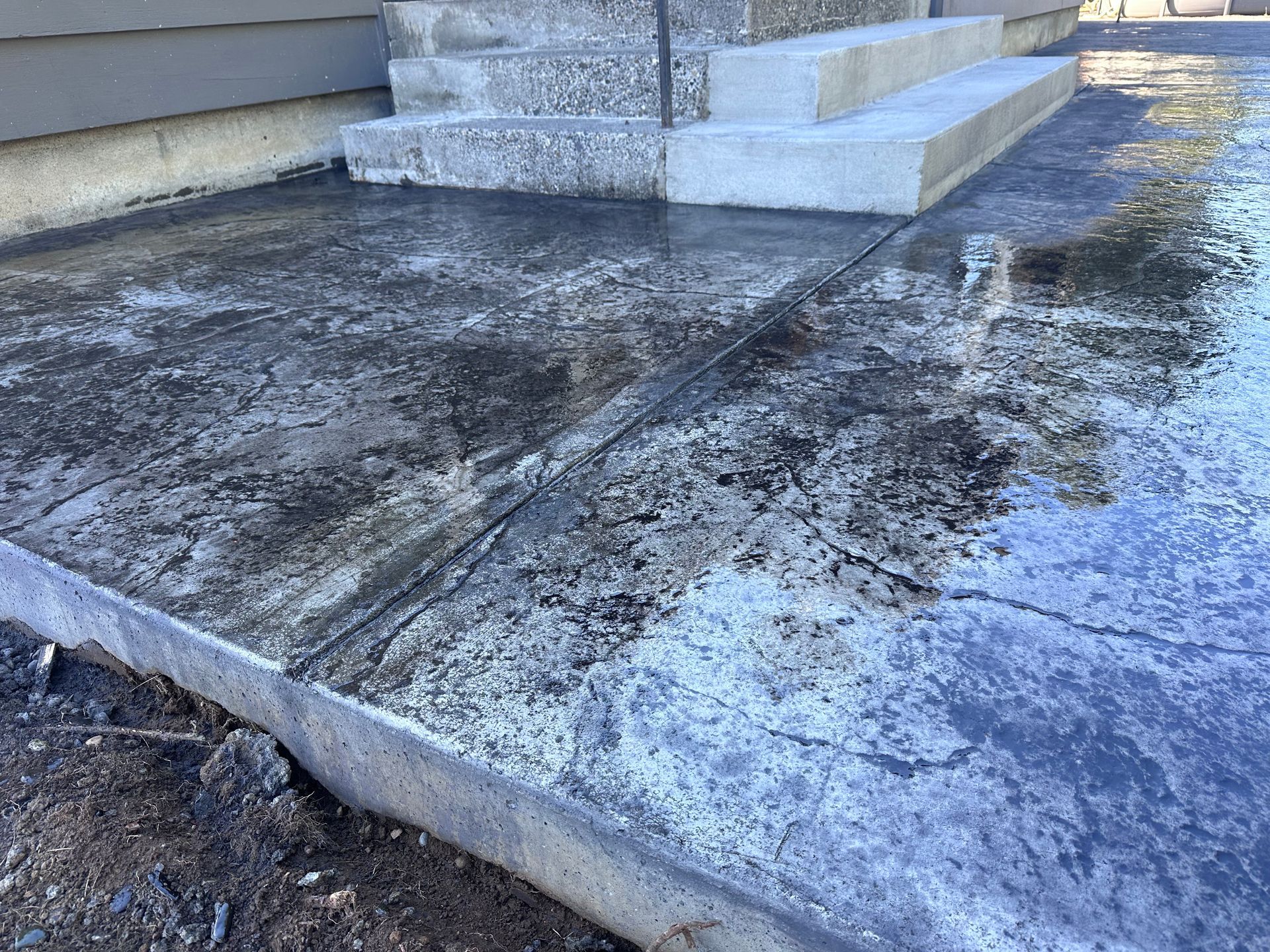 A concrete walkway with steps leading up to a house.