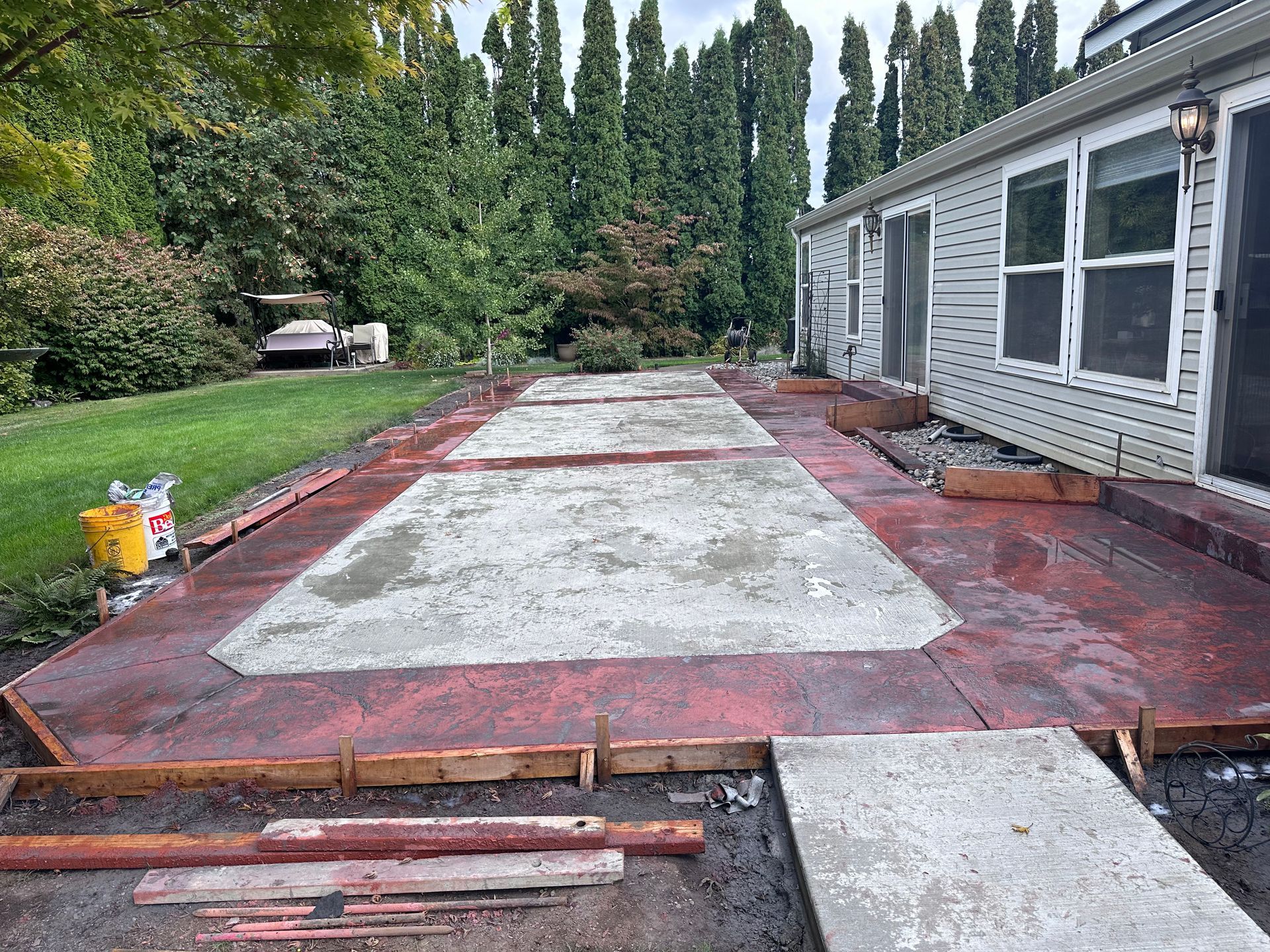 A concrete driveway is being built in front of a house.