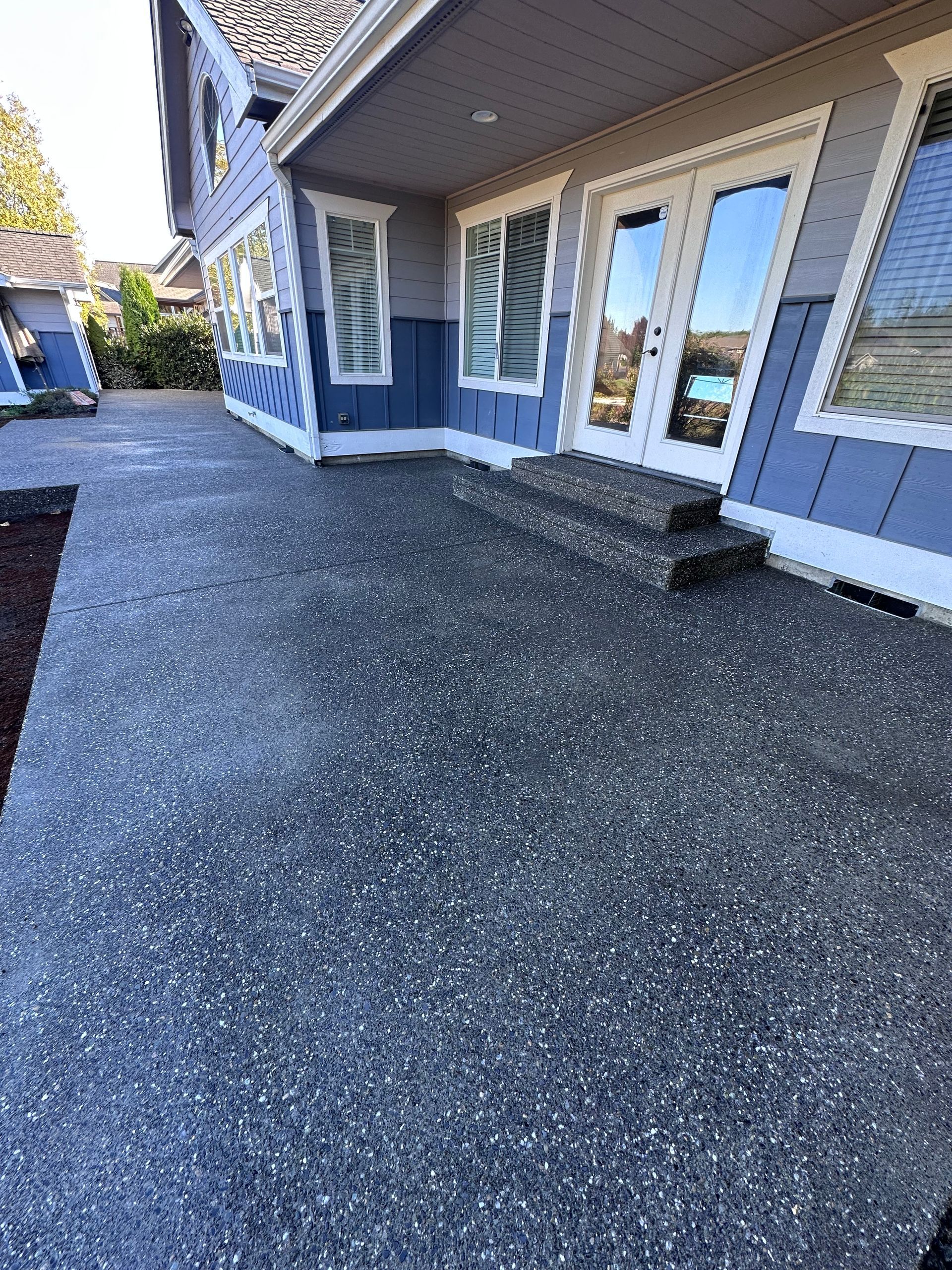 A large house with a patio and stairs in front of it.