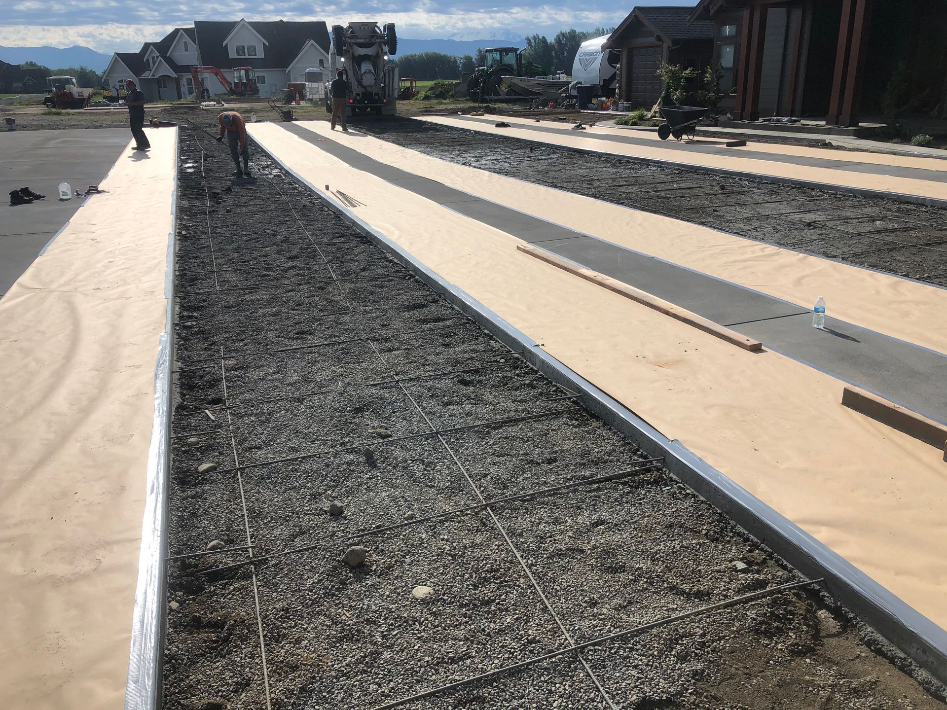A concrete walkway is being built in front of a house.
