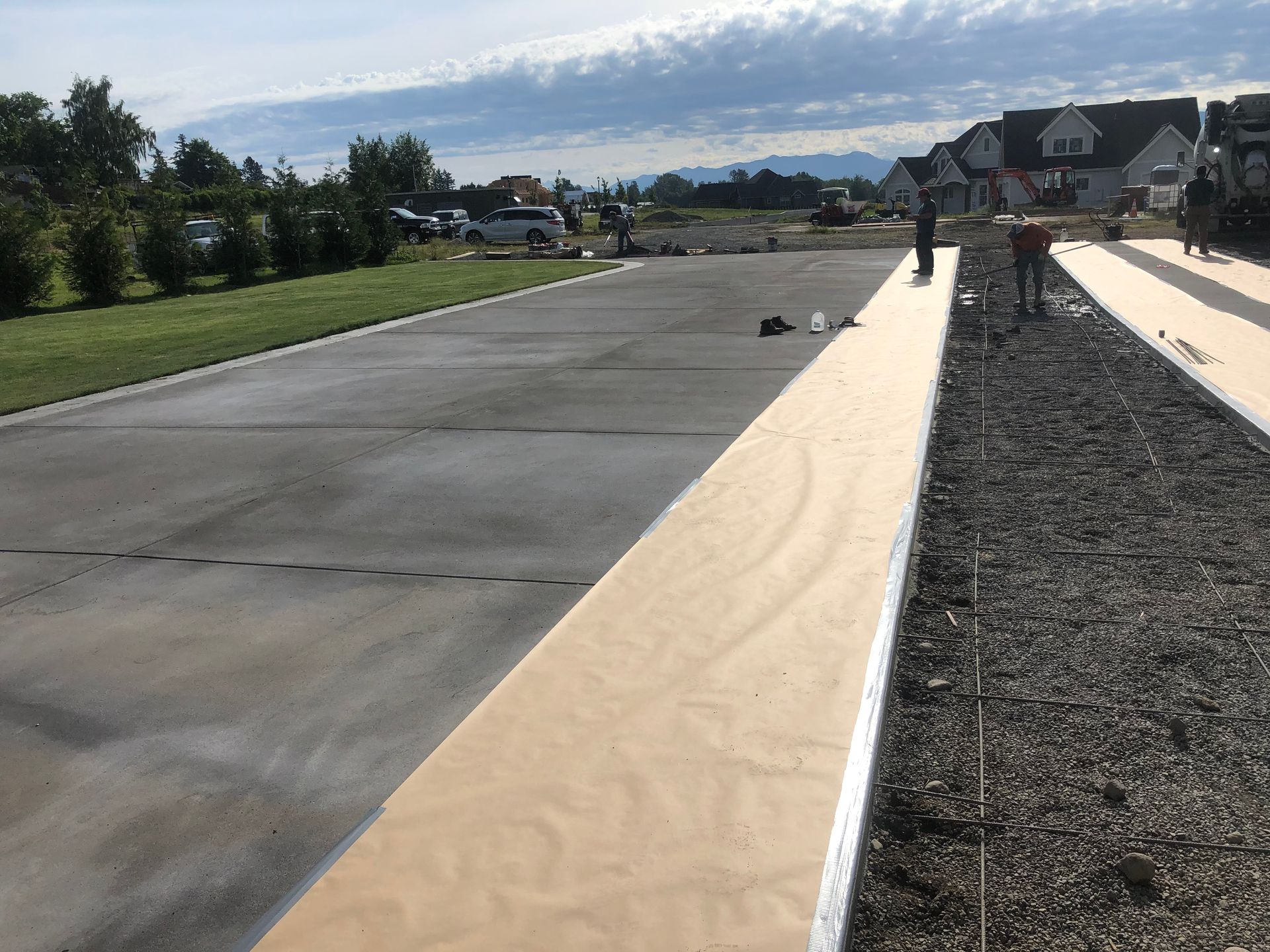A concrete driveway with a wooden walkway in the middle of it
