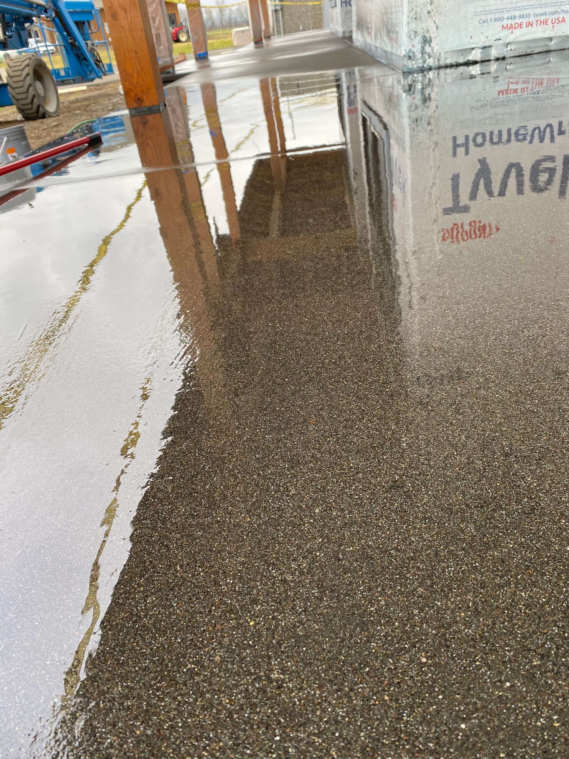 A reflection of a box in a puddle of water on a concrete floor.