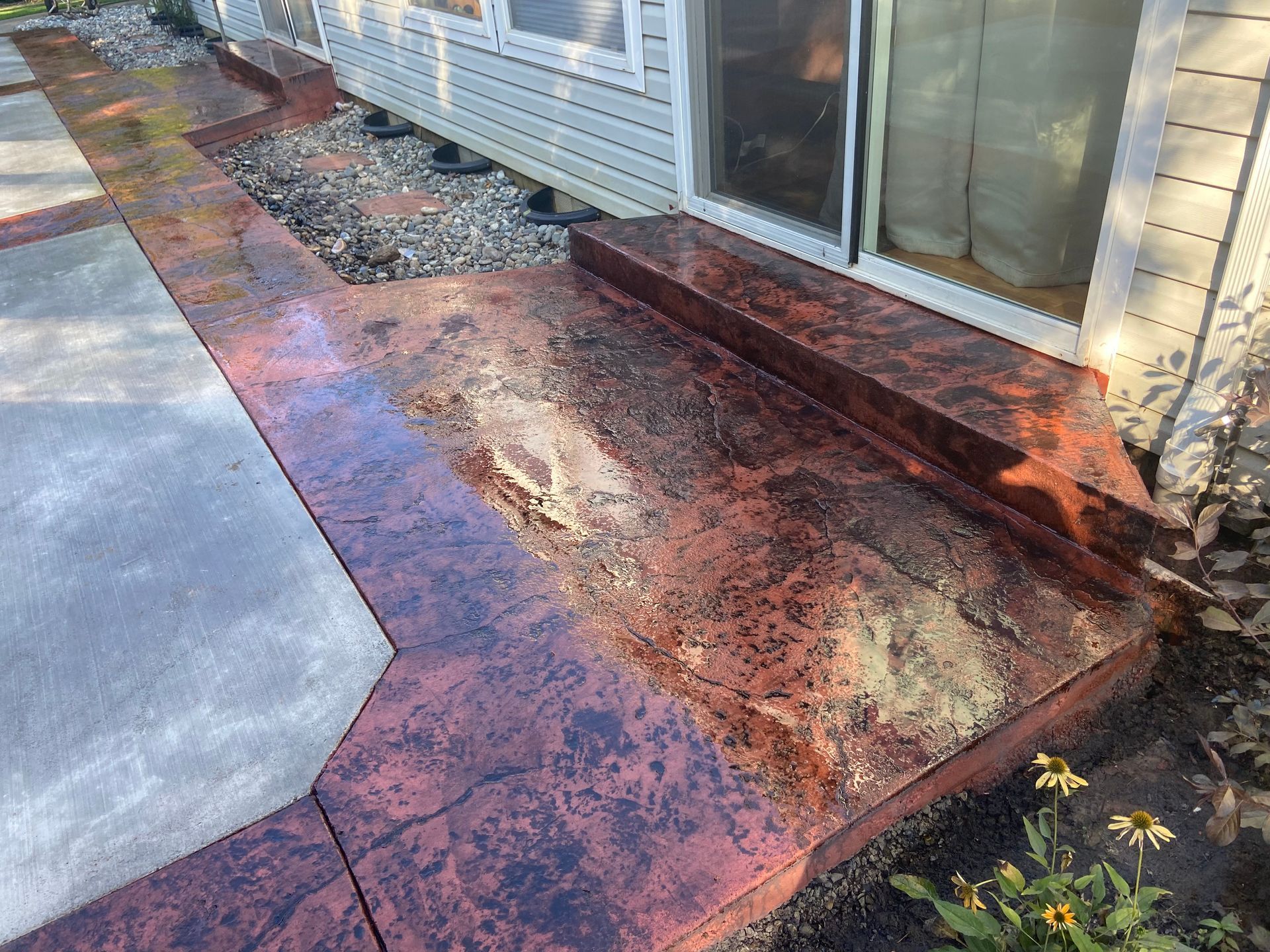 A concrete walkway with steps leading to a house.