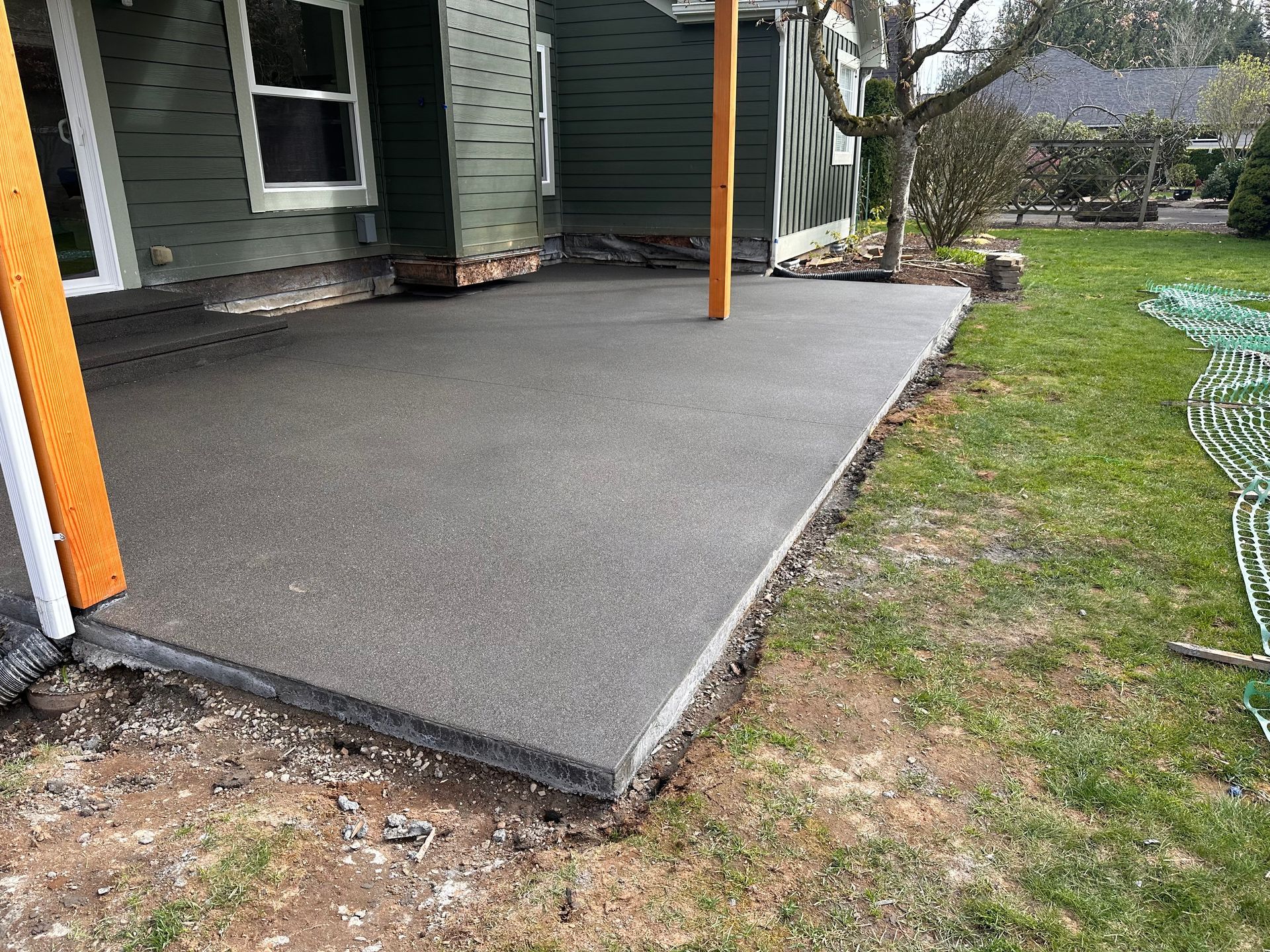 A concrete patio is being built in front of a house.