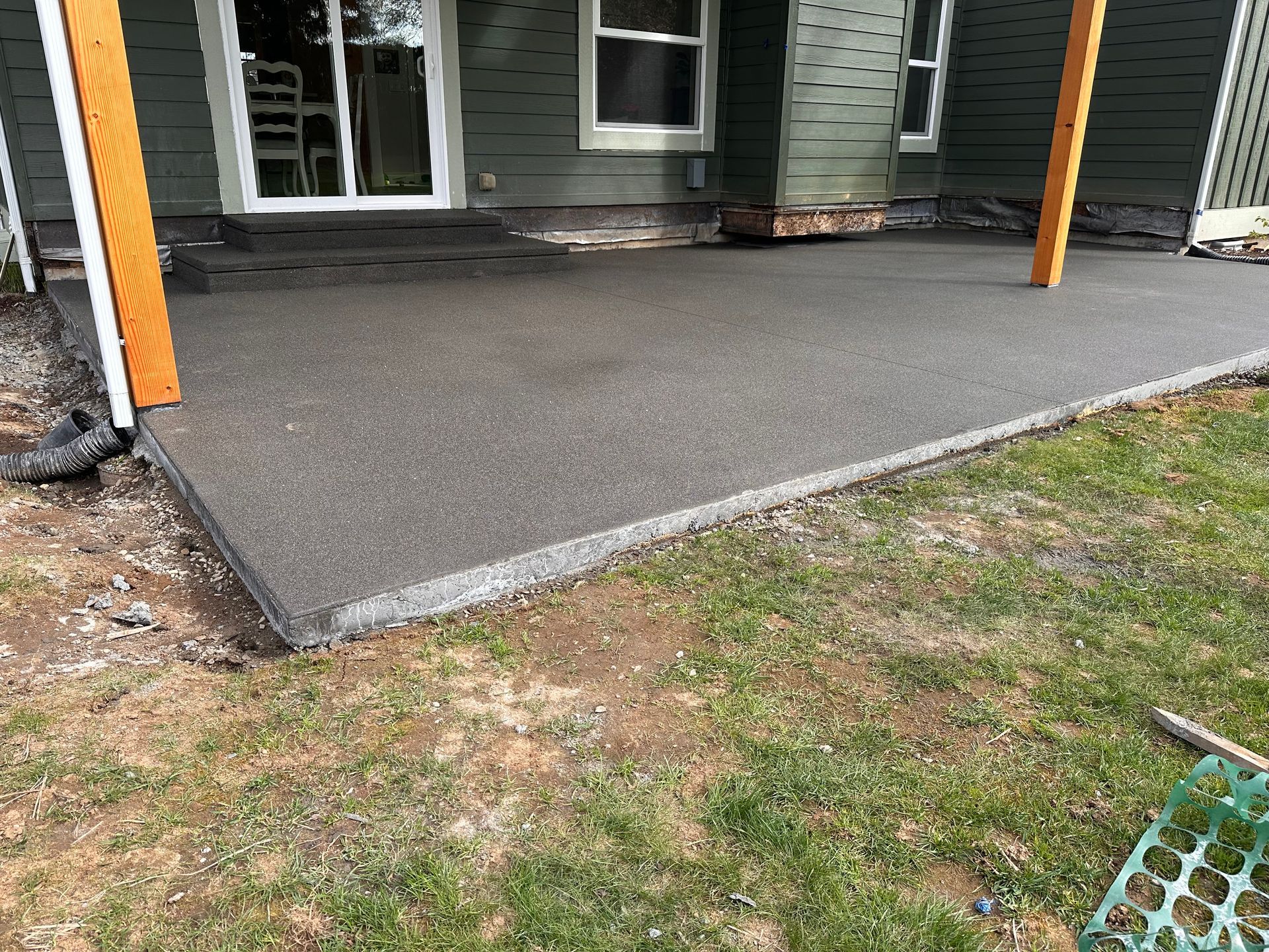 A concrete patio is being built in front of a house.