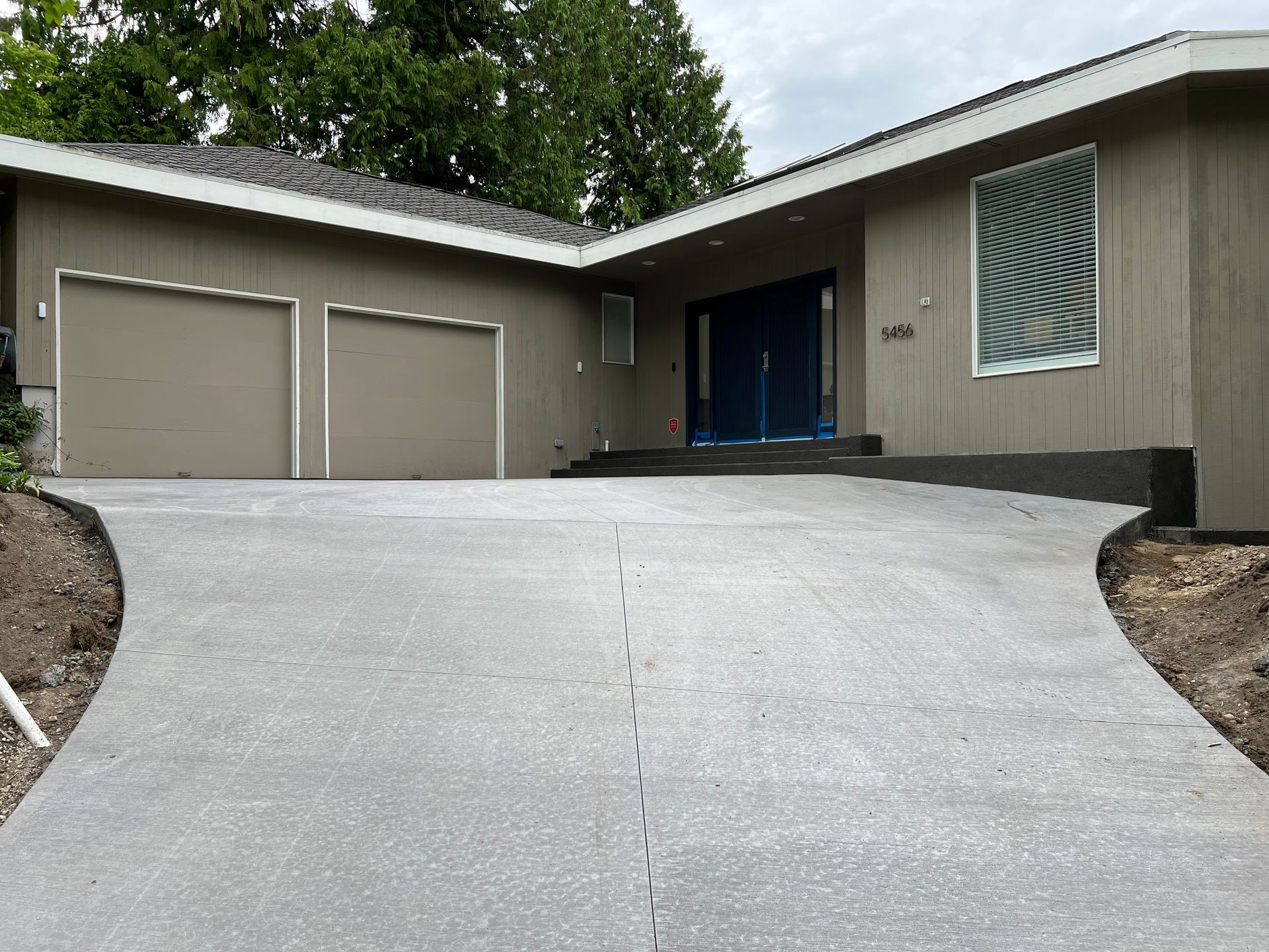 A large house with a concrete driveway leading to it