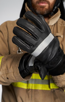 Bombero con guantes negros con bandas reflectantes.