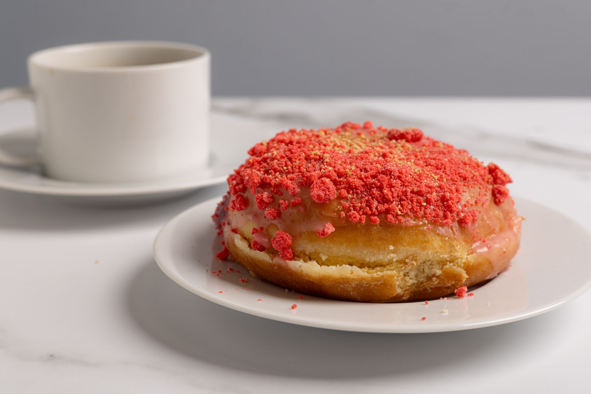 A freshly made donut, covered in sugar crystals