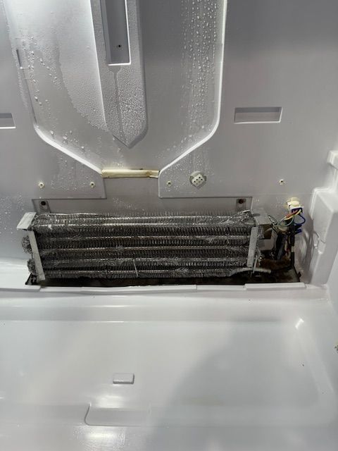 The inside of a refrigerator with a broken ice maker.