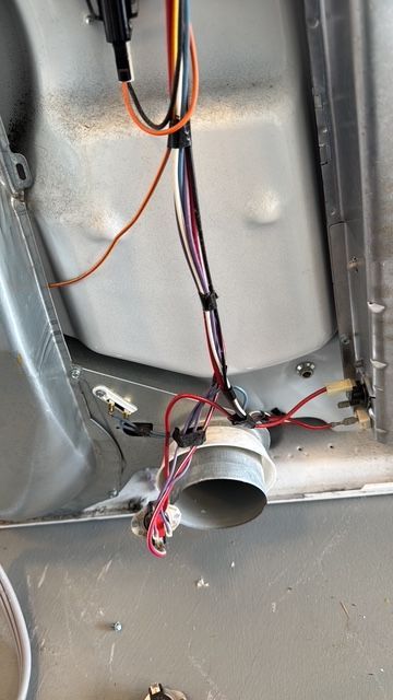 A close up of a washer and dryer with wires coming out of it.