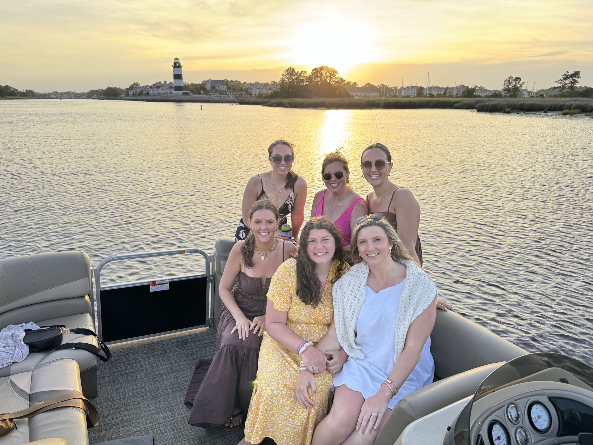 Sunset over ocean, orange and pink sky reflects on water.