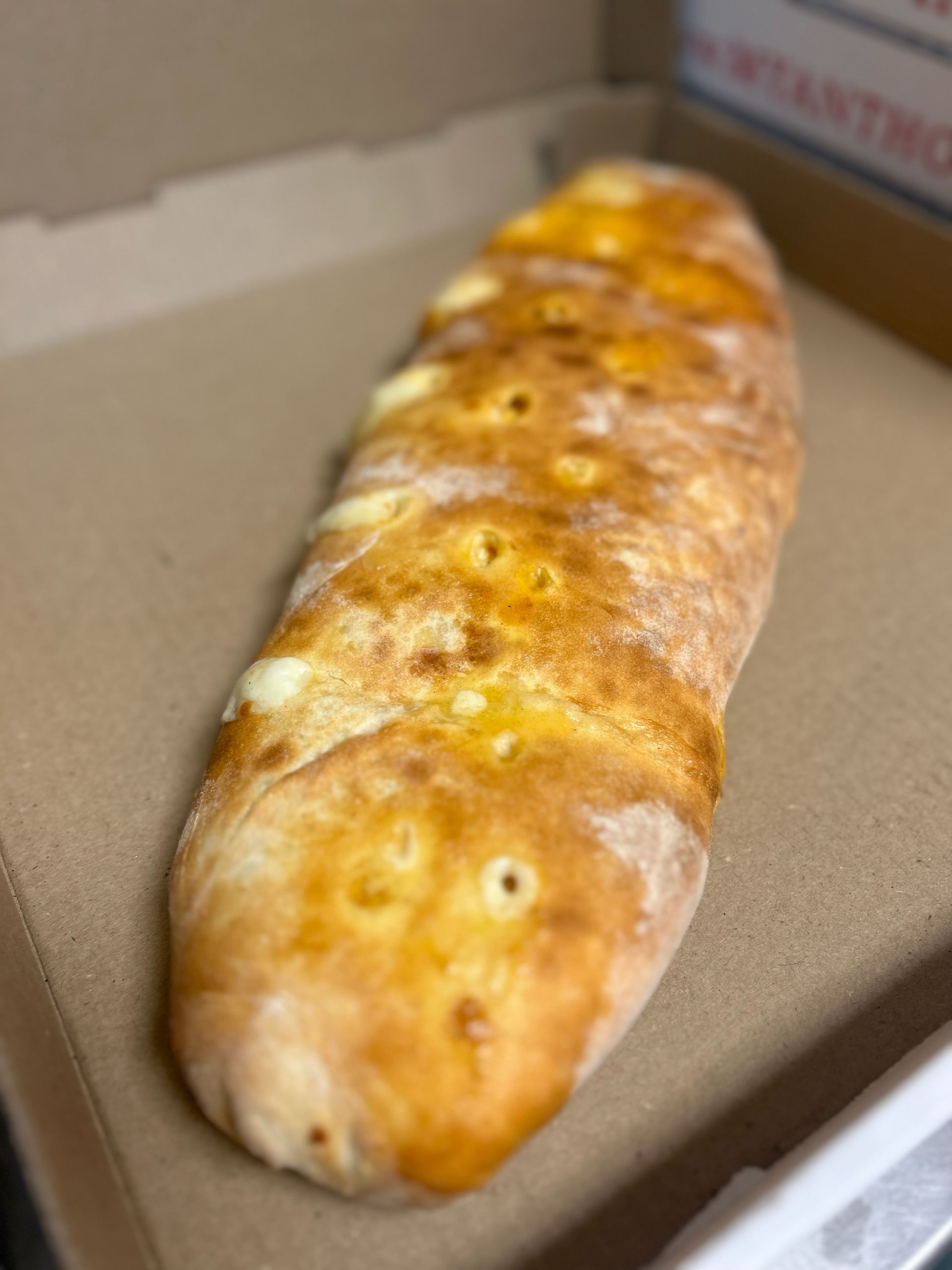 Golden-brown braided bread loaf in a cardboard box