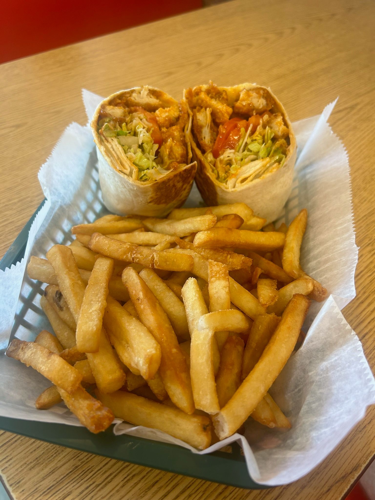 Wrap halves and fries in a basket on a table