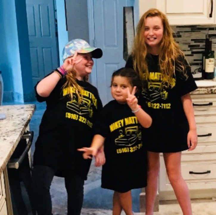 three young girls wearing mikey mattress shirts pose for a picture