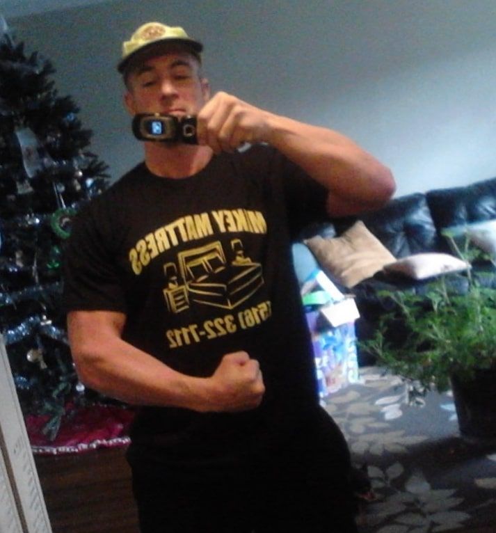 a man taking a picture of himself in a miket mattress shirt