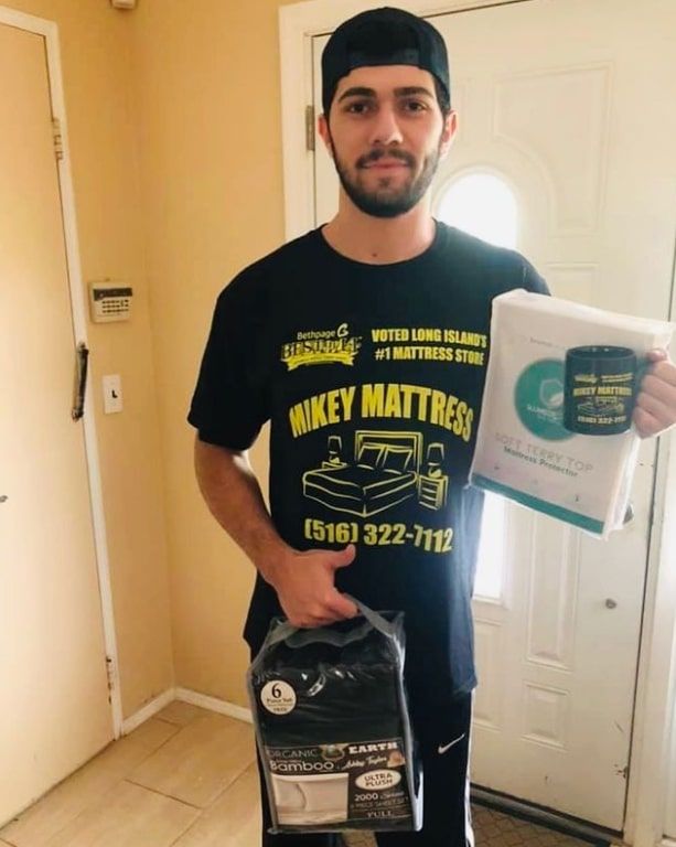 a man wearing a black shirt that says mikey mattress