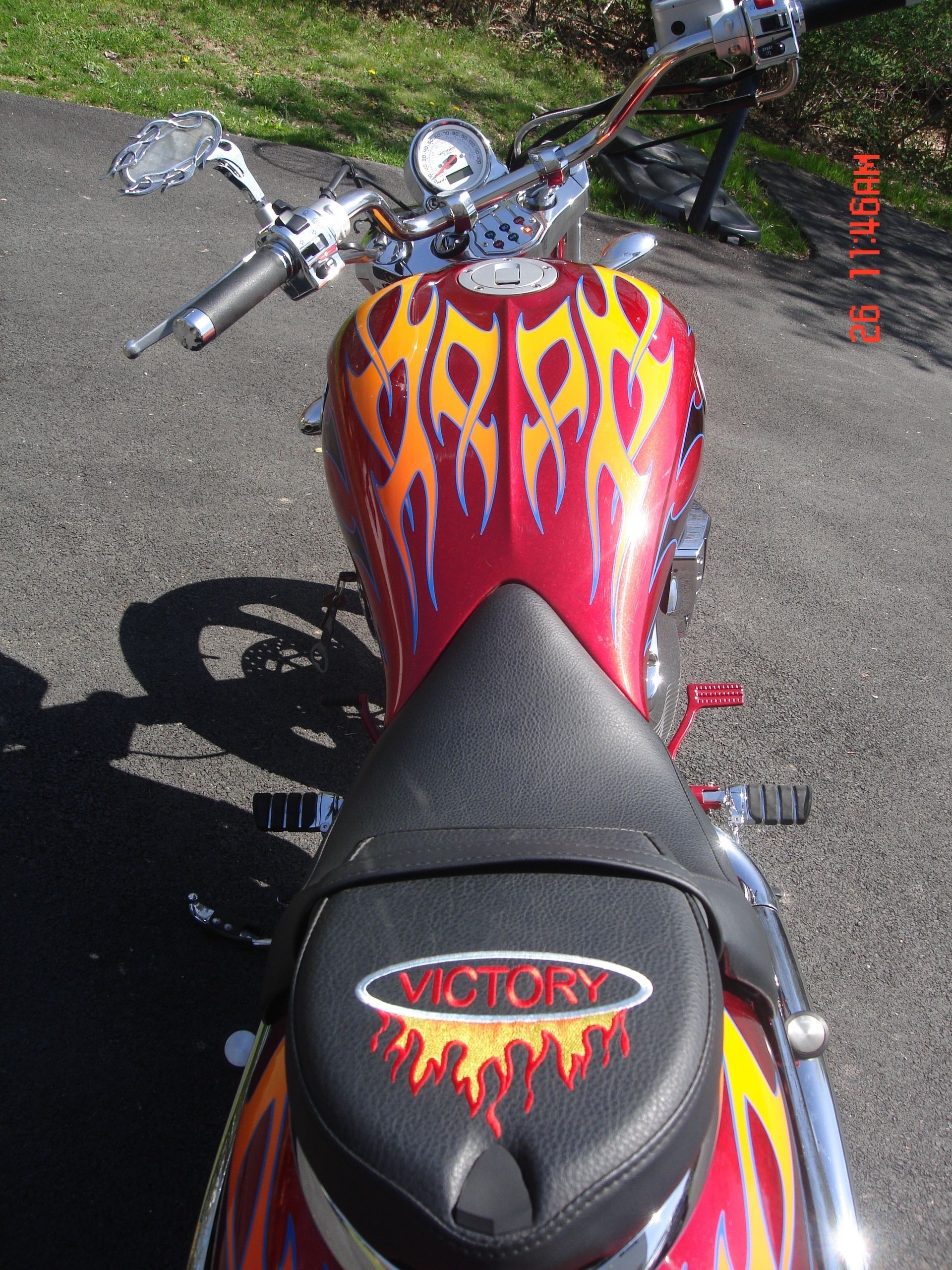 A top-down view of a Victory motorcycle featuring a red gas tank and seat adorned with flame graphic designs.