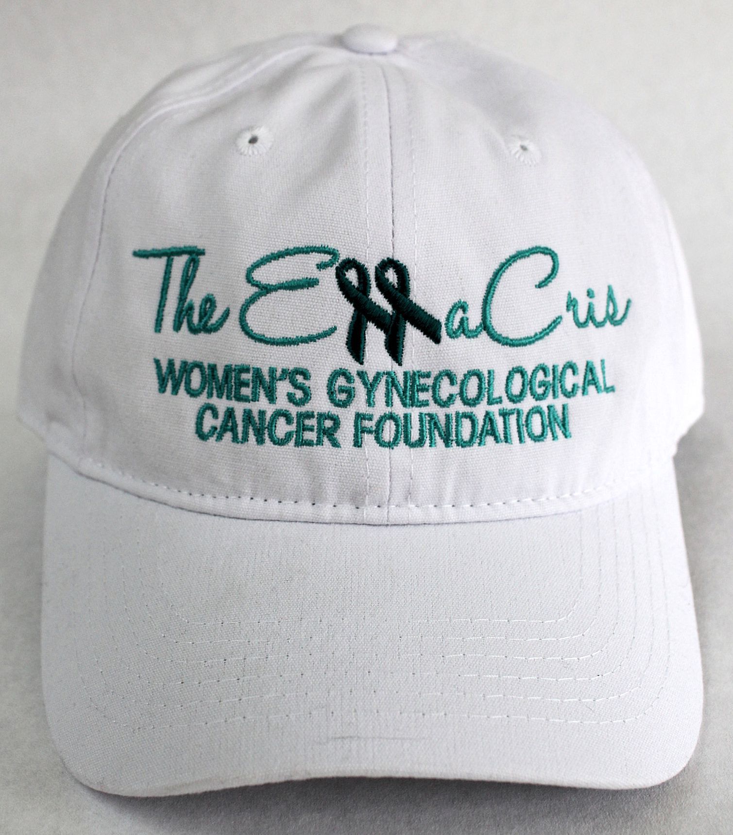 A white baseball cap featuring teal green text reading A white baseball cap featuring teal green text reading