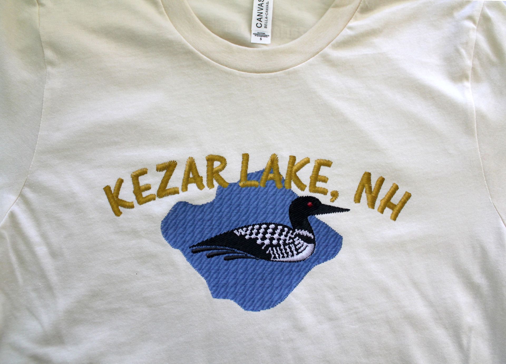 White quilted horse saddle pad embroidered with a logo featuring the letters White quilted horse saddle pad embroidered with a logo featuring the letters