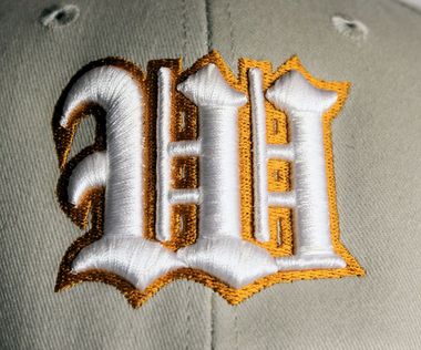 A light beige baseball cap with the words 