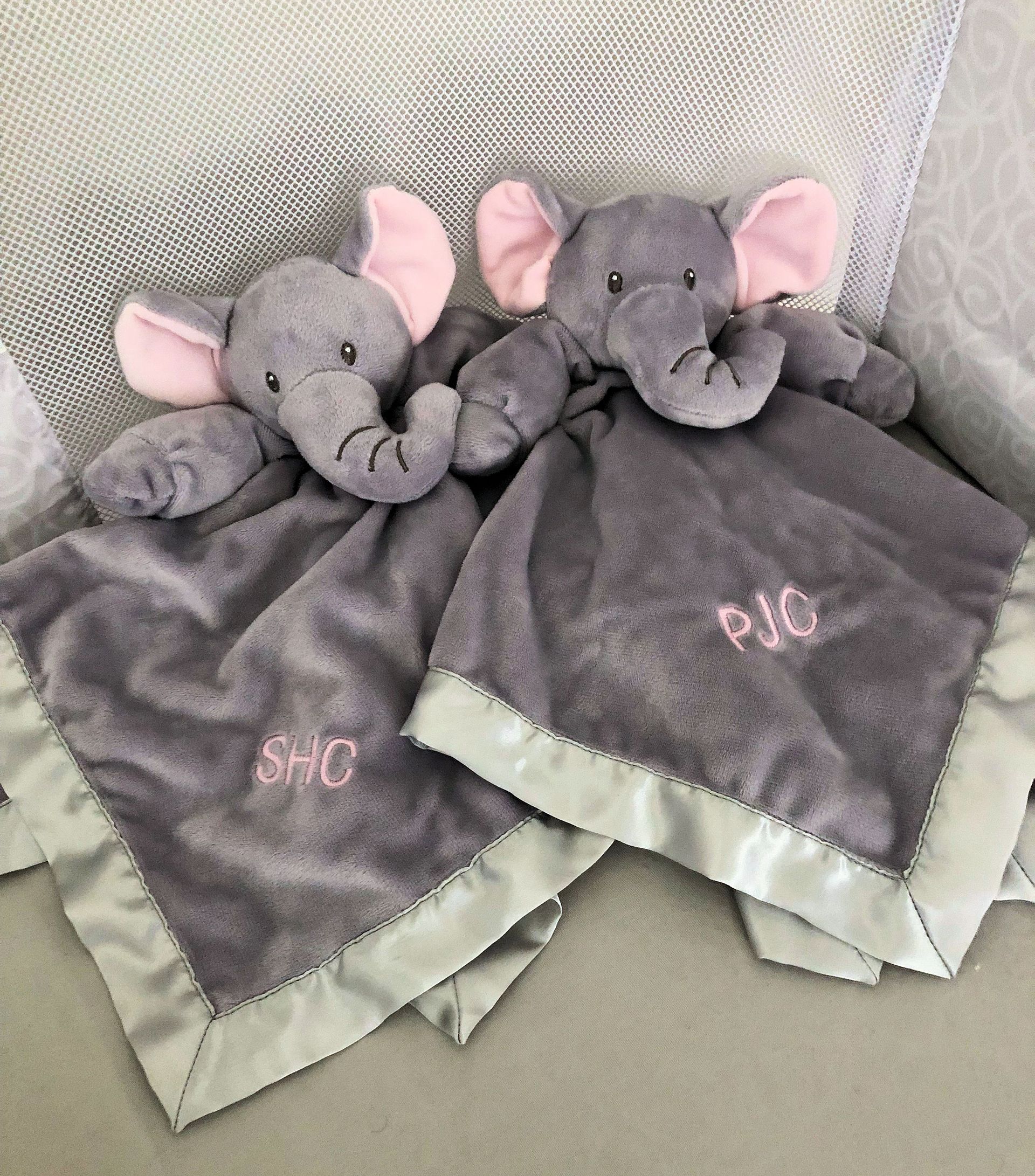 A cream-colored t-shirt with an embroidered blue lake shape, a black and white loon, and the text A cream-colored t-shirt with an embroidered blue lake shape, a black and white loon, and the text