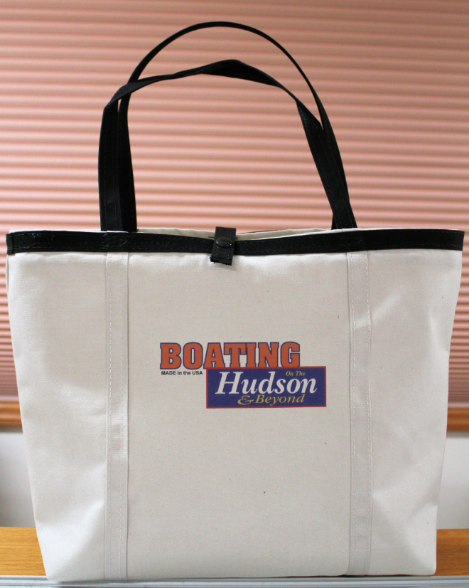 A white canvas tote bag with black handles and a logo that reads A white canvas tote bag with black handles and a logo that reads