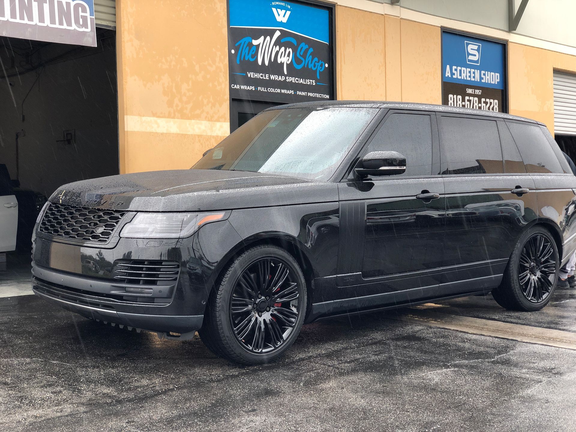 a black range rover is parked in front of the wrap shop