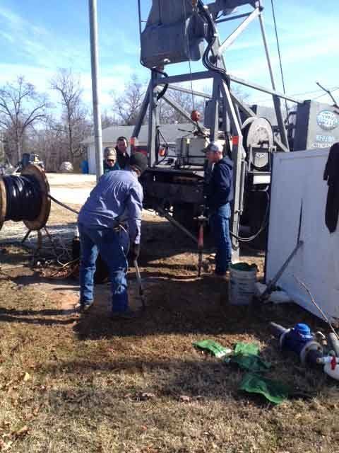 Drilling Contractor — Man Setting Up Drill in Crane, MO