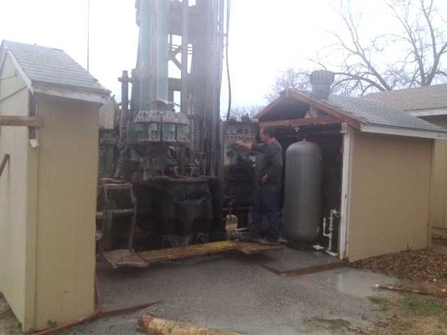 Man Setting Up a Water Pump — Crane, MO — Lefty's Pump & Drilling