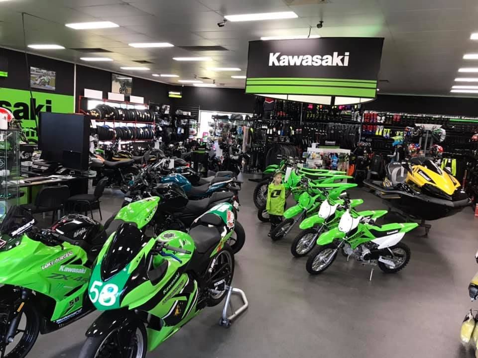 A Row of Green Kawasaki Motorcycles Are Lined Up in a Showroom — Mackay Kawasaki in North Mackay, QLD