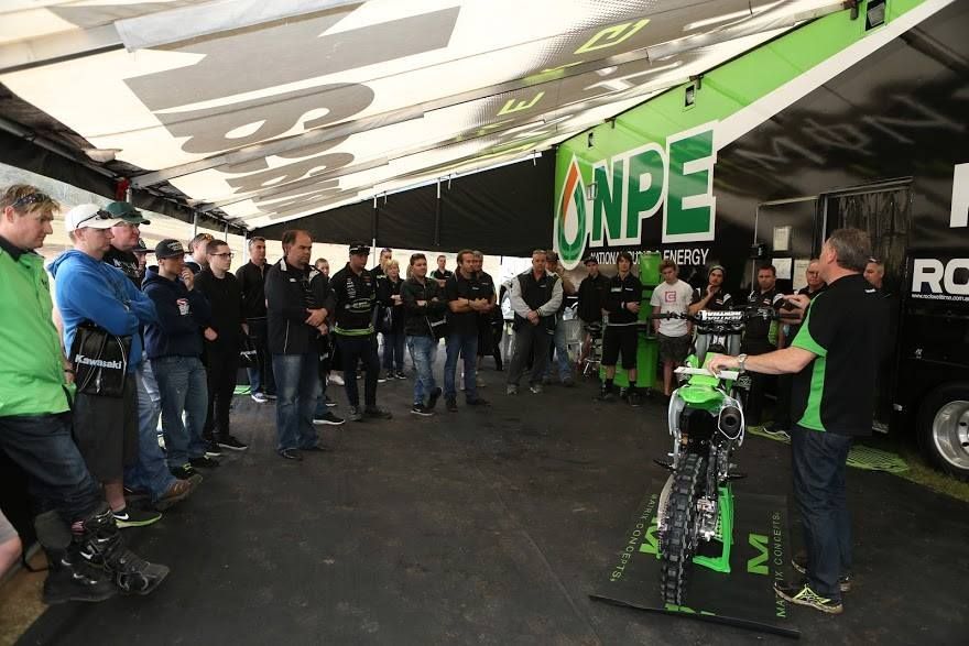 A Man Is Talking to A Group of People in Front of A Sign — Mackay Kawasaki in Mackay, QLD