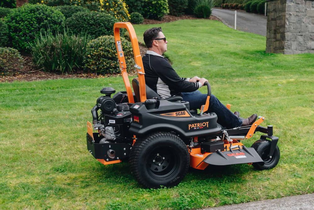 A Man is Riding a Lawn Mower on a Lush Green Lawn — Mackay Kawasaki in North Mackay, QLD