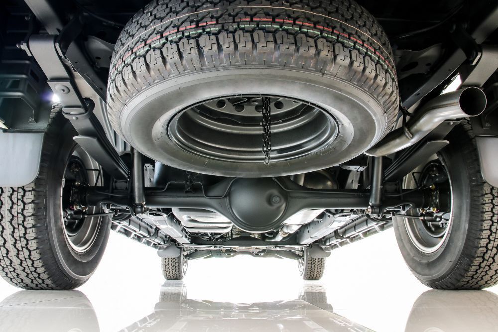 Underside of a truck with tires, spare tire, exhaust pipe, and mechanical components. | Elite Autocare of Princeton