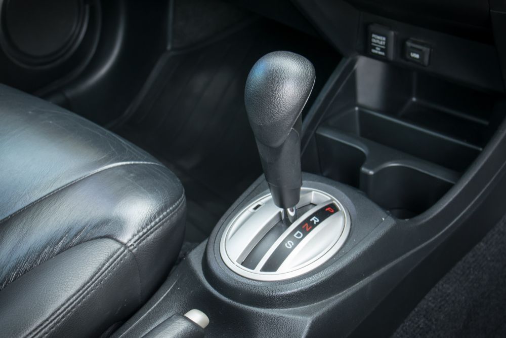Black car interior with automatic gear shift, next to black leather seat. | Elite Autocare of Princeton