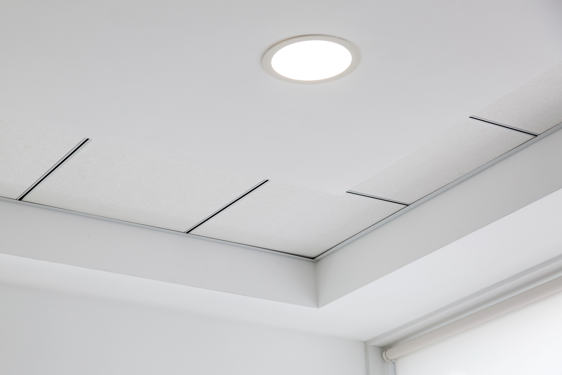White ceiling with a recessed light and dark lines.