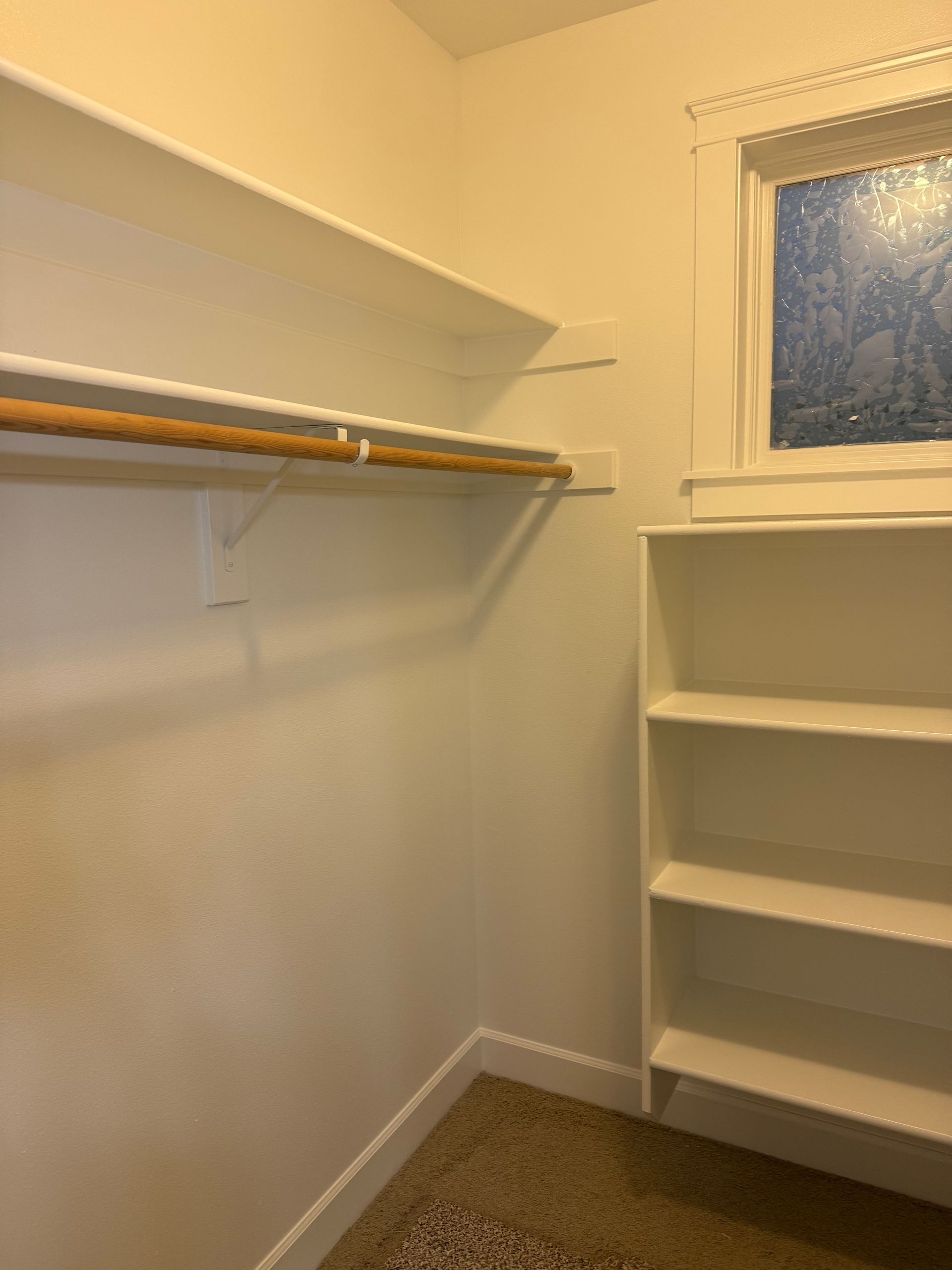 A corner of a room with a wooden floor and a door.