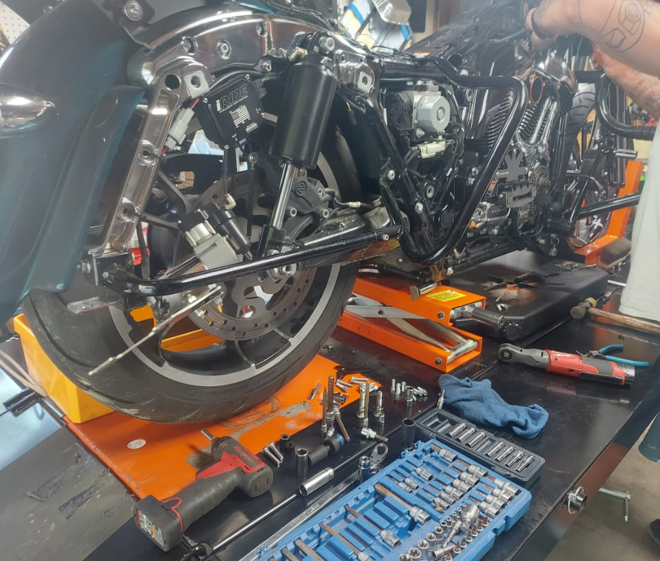 A person is working on a motorcycle in a garage.