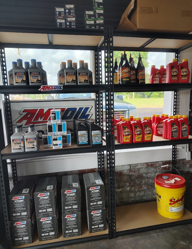 A shelf filled with lots of bottles of amsoil oil