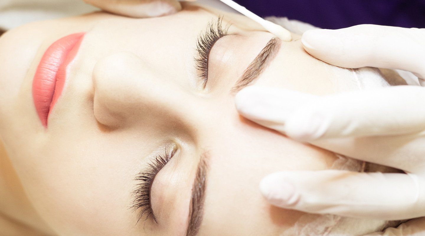 Micro blading expert working on women face