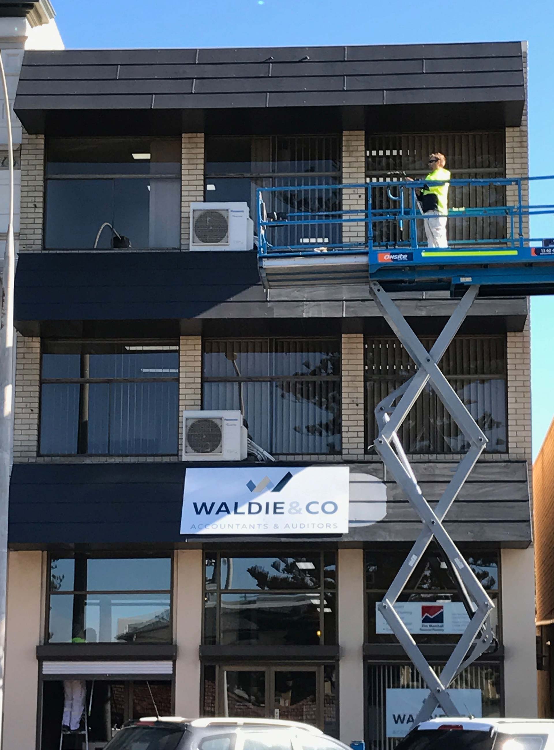 Man painting a 3 story building