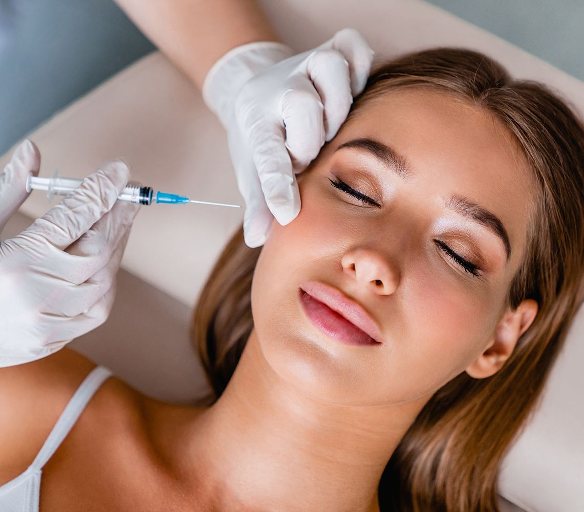 A woman is getting a botox injection in her face.