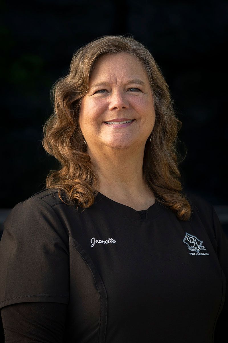 A woman in a black shirt is smiling for the camera.